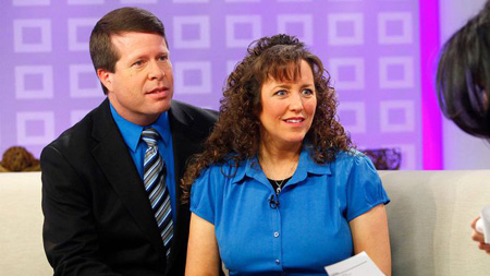 Jim Bob and Michelle Duggar sitting on a couch.